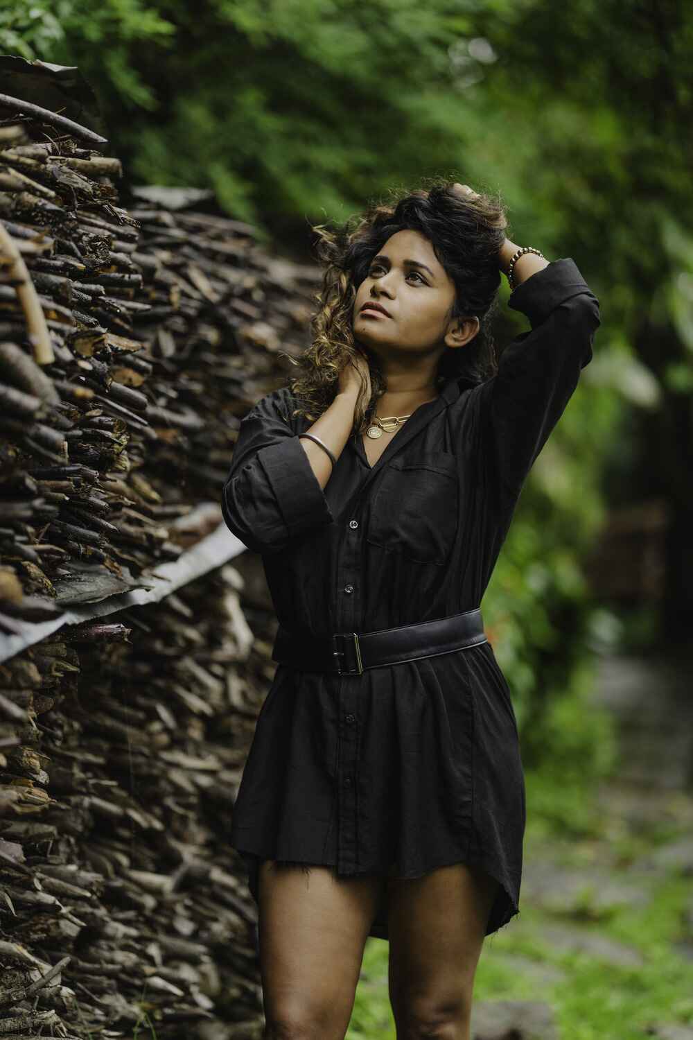 Model wearing a black linen cotton shirt dress with a button-down closure and a belt on the front.