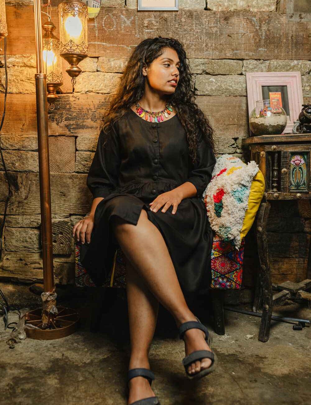 Model in a comfy black linen-cotton short dress for women with three-quarter sleeves, standing outdoors.