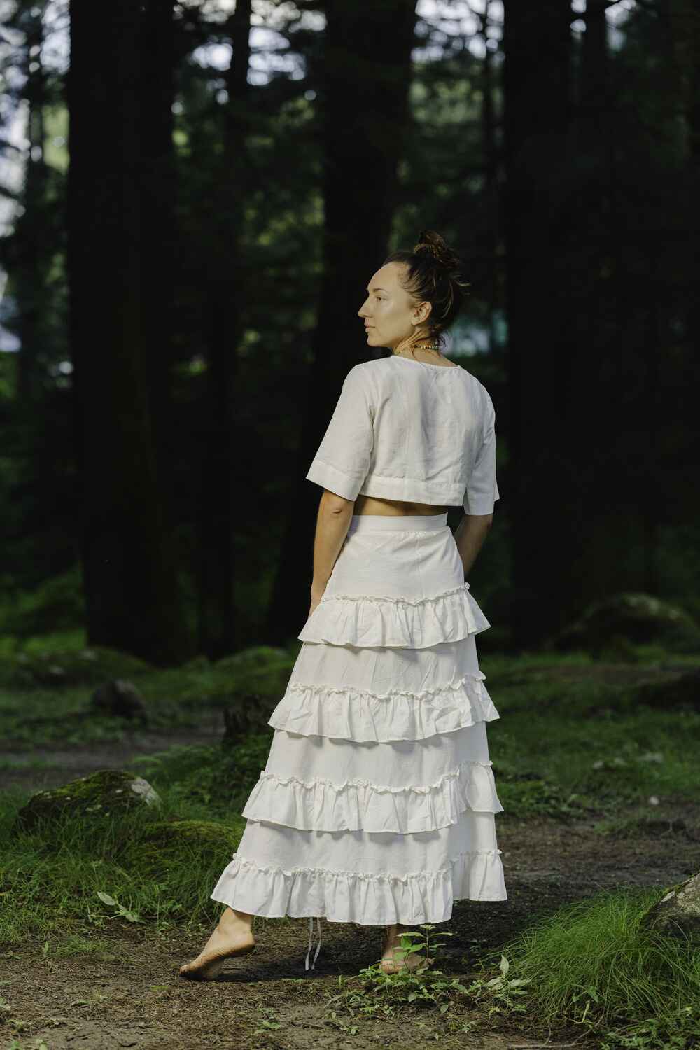 Model wearing a beautiful white cotton linen skirt with ruffles and a flowing design