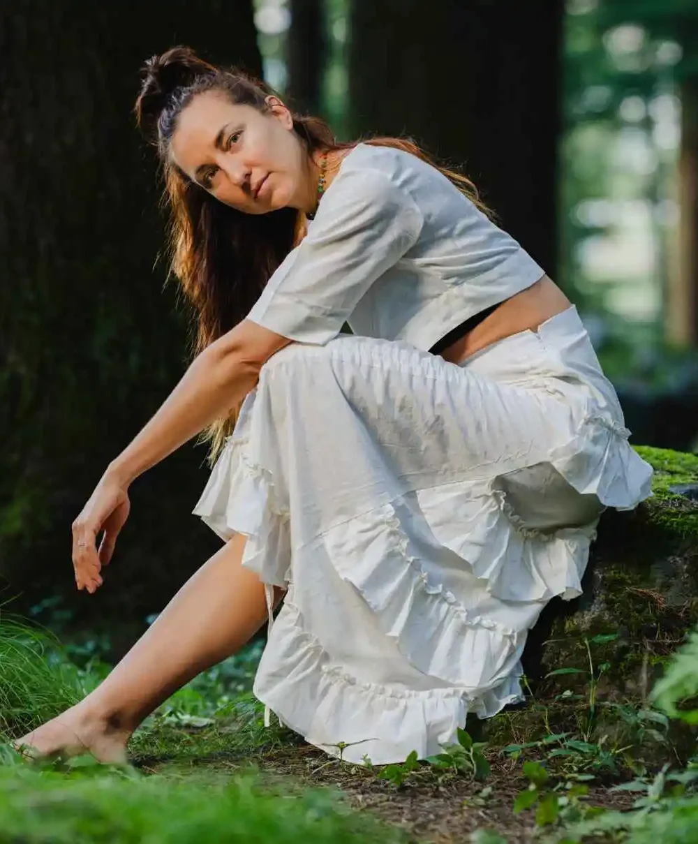 Model wearing a beautiful white cotton linen skirt with ruffles and a flowing design.