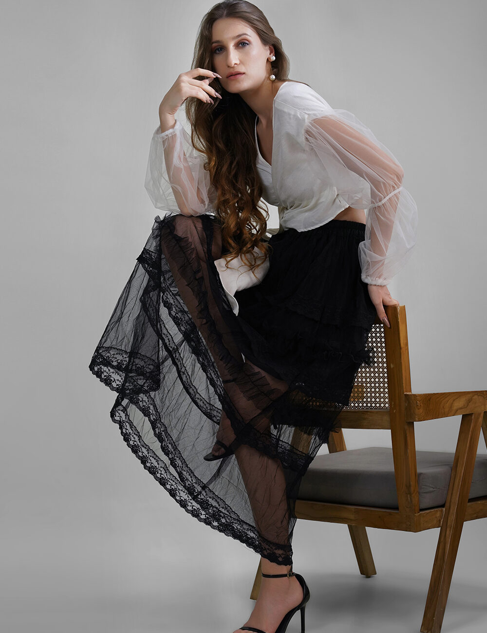 Model wearing white shimmer wrap blouse with balloon butterfly net sleeves