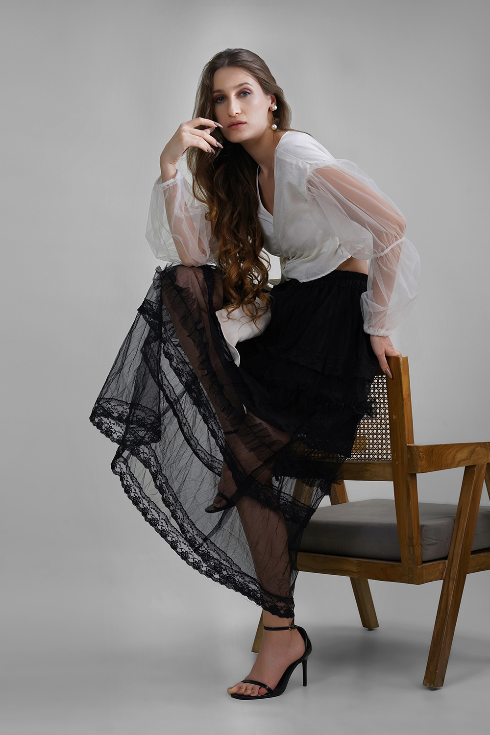 Model wearing white shimmer wrap blouse with balloon butterfly net sleeves