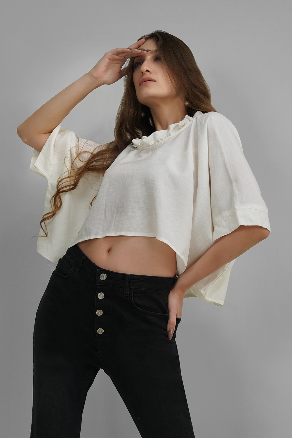 Model in a white oversized crop top with ruffled neck and elbow-length sleeves