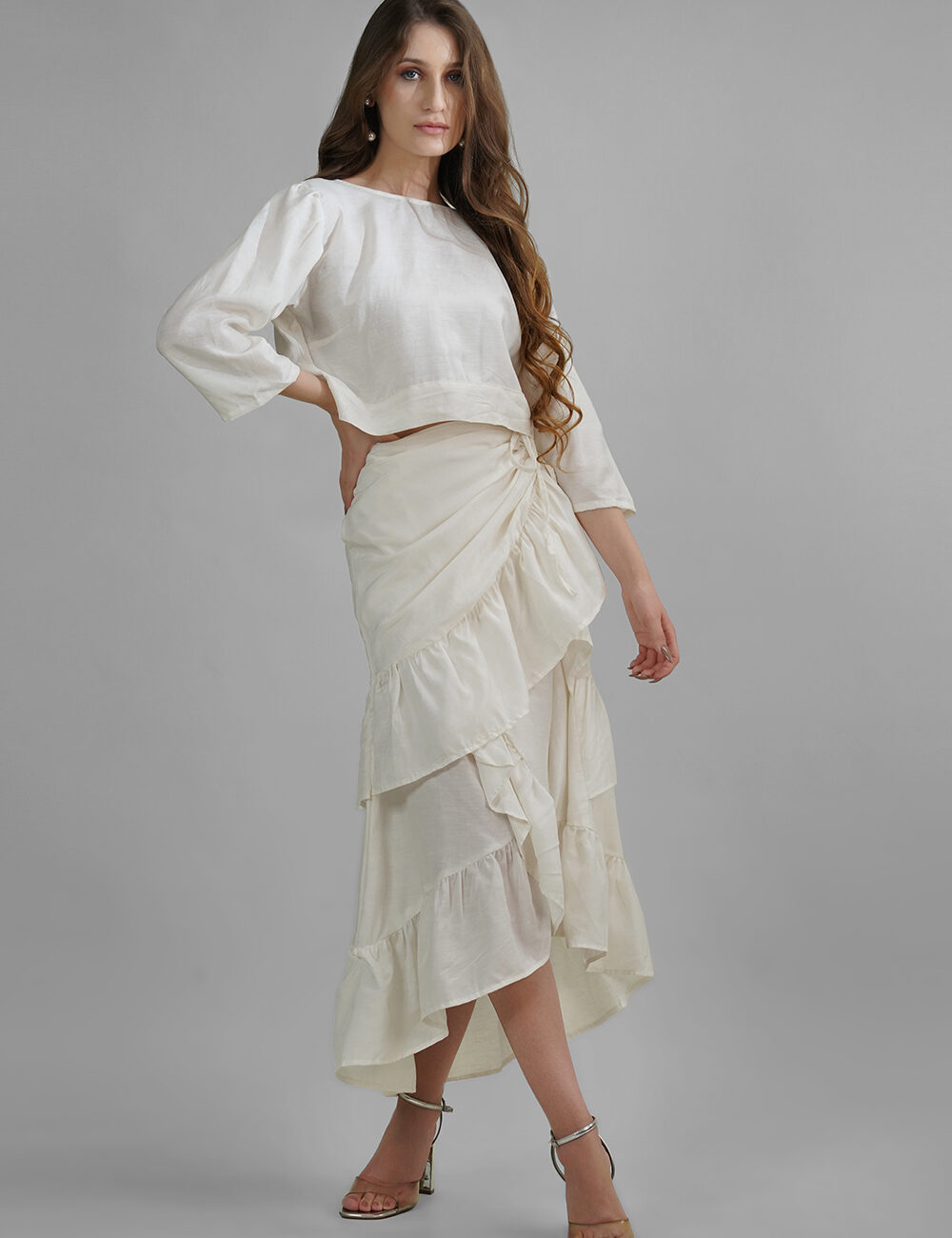 Model wearing a cream cotton-linen crop top with back buttons and 3/4 sleeves