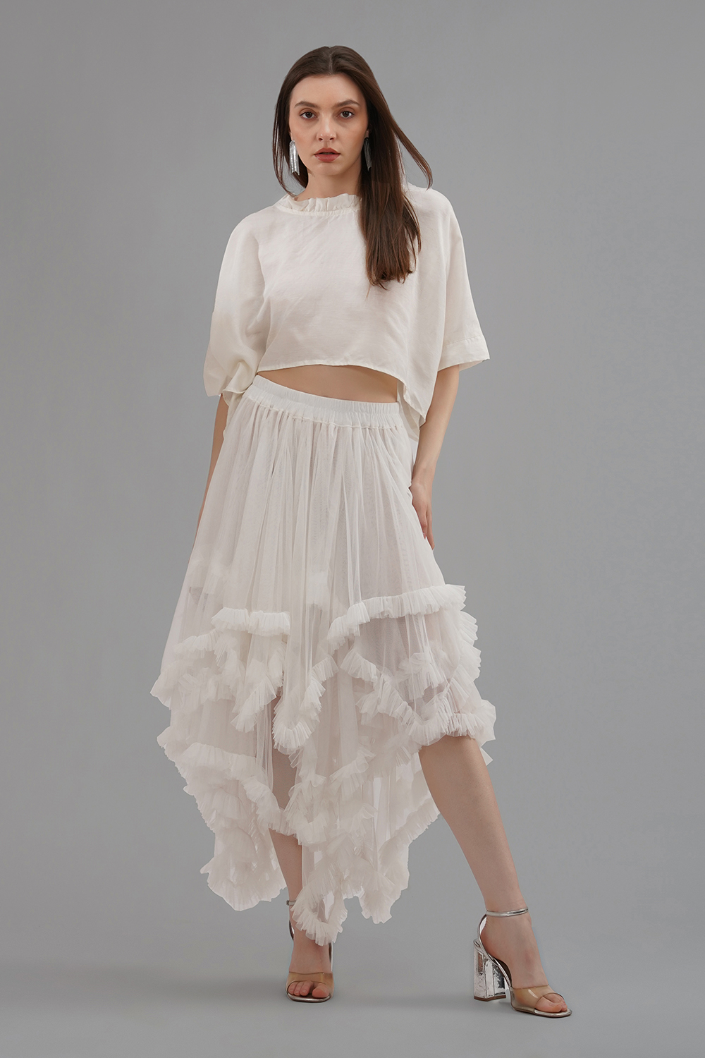 Model wearing a convertible ivory soft net ruffled skirt with lace details