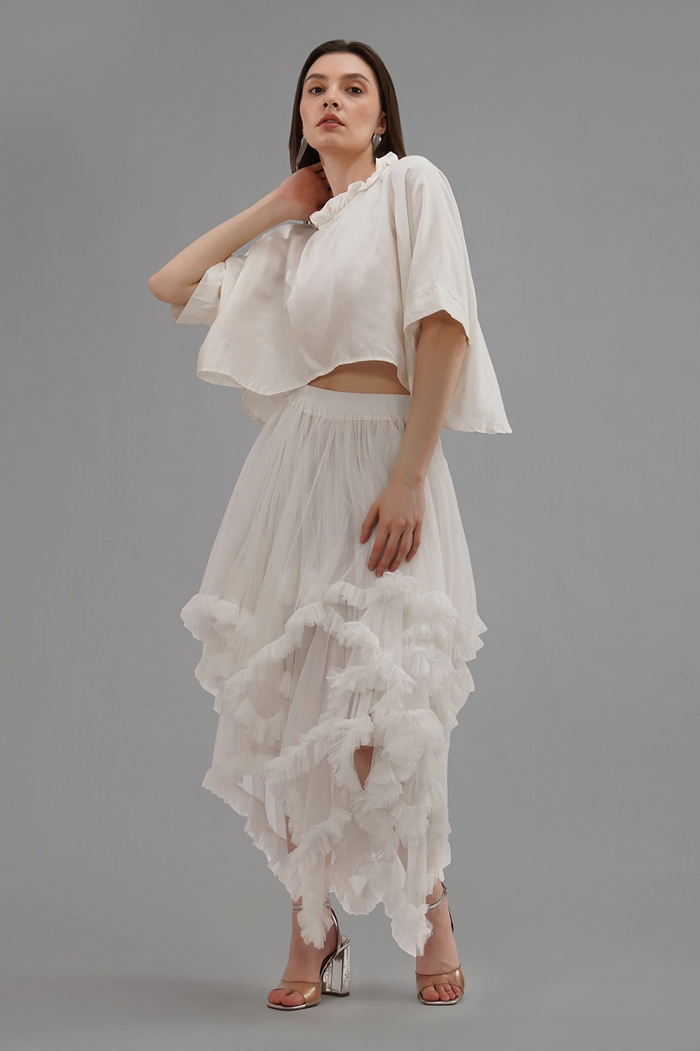 Model wearing a convertible ivory soft net ruffled skirt with lace details