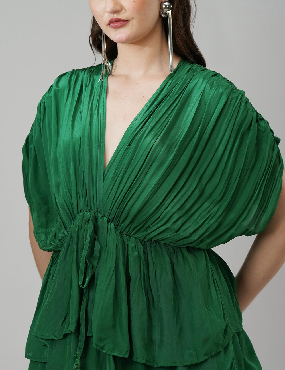 Model wearing emerald green 3-layered V-neck party dress in natural crape