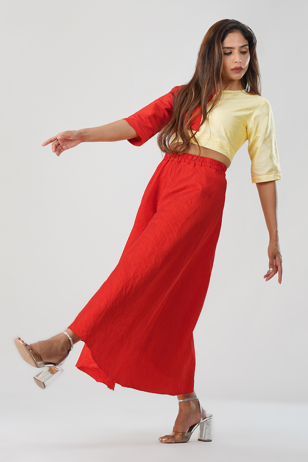 Model wearing red & yellow dhupian silk co-ord set with palazzo pants and crop top